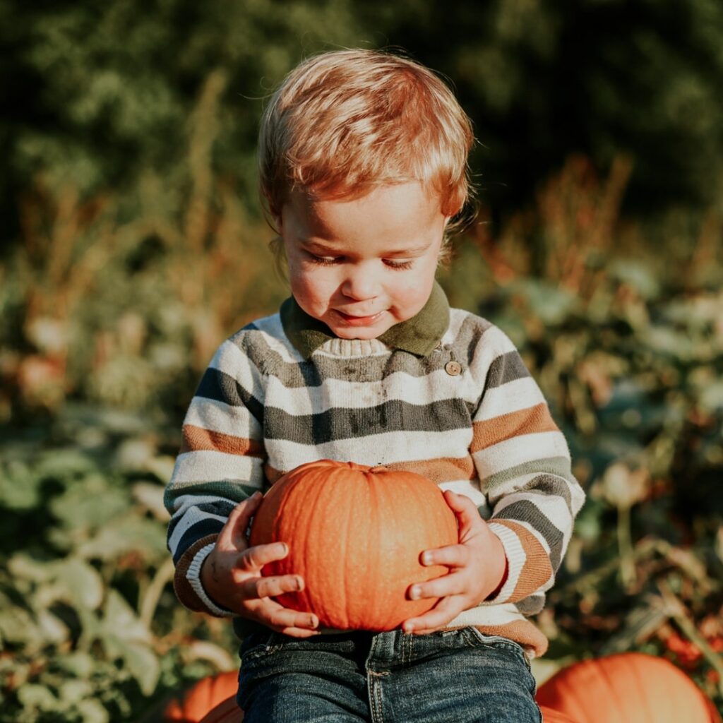 child with pumpkin